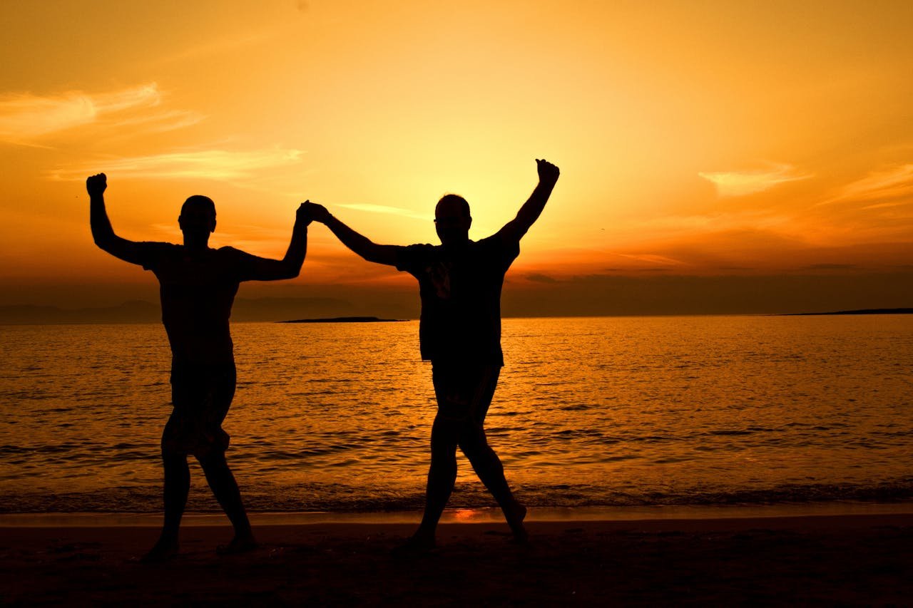 Silhouette of a joyful couple dancing on a beach at sunset, capturing the essence of happiness and romance.